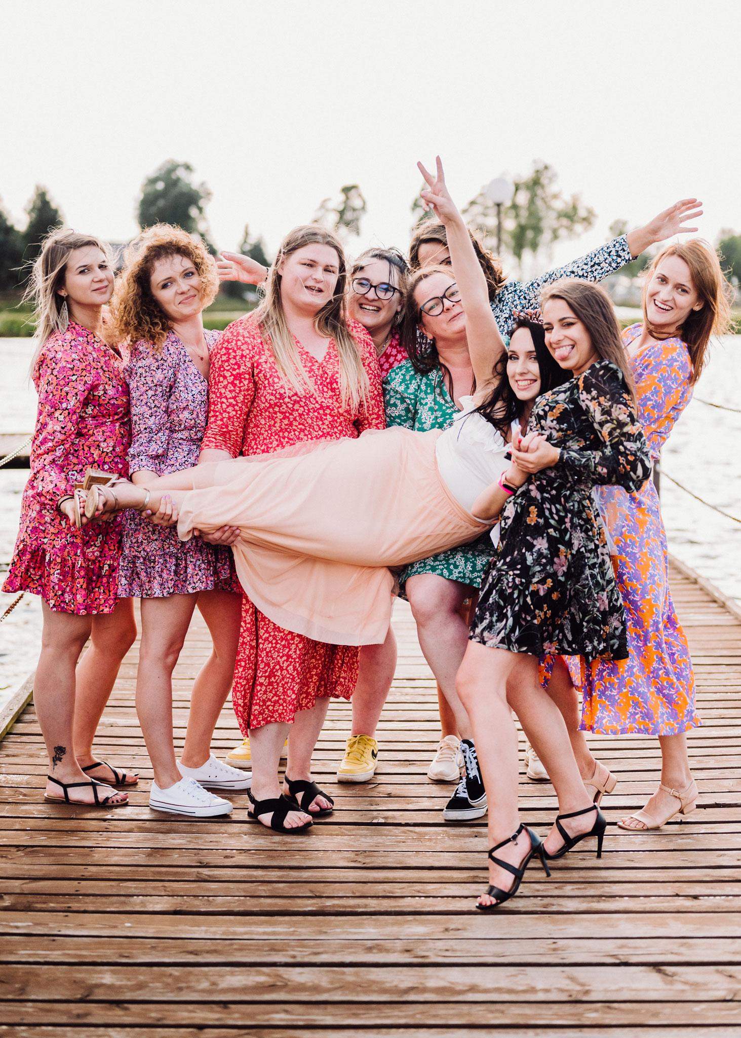 Grupa dziewczyn trzymająca przyszłą panią Młodą