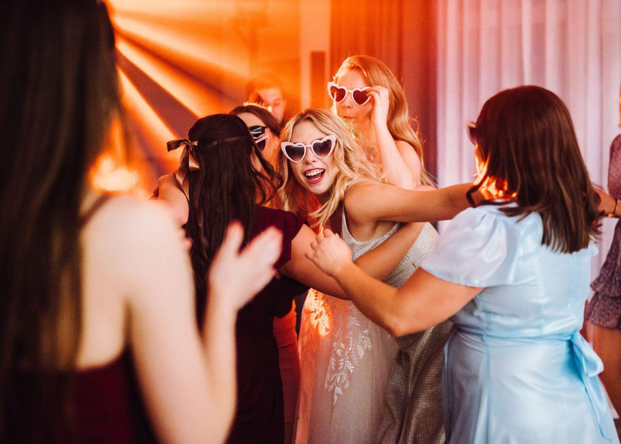 Panna Młoda tańcząca w białej sukni o zachodzie słońca na mocno zielonej łące