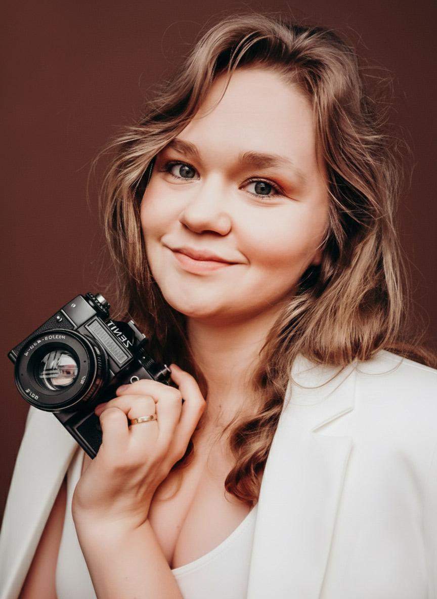 Portret fotografki trzymającej w ręku aparat na brązowym tle